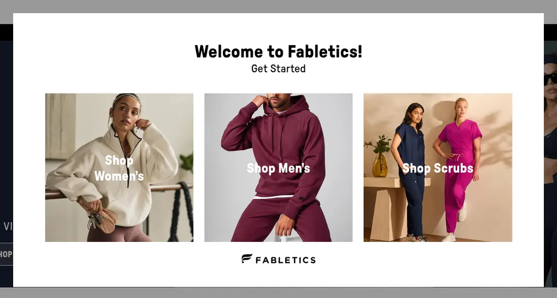Fabletics lead form screen 1: a welcome popup over the home page asking you to choose Shop Women&#x27;s, Shop Men&#x27;s or Shop Scrubs